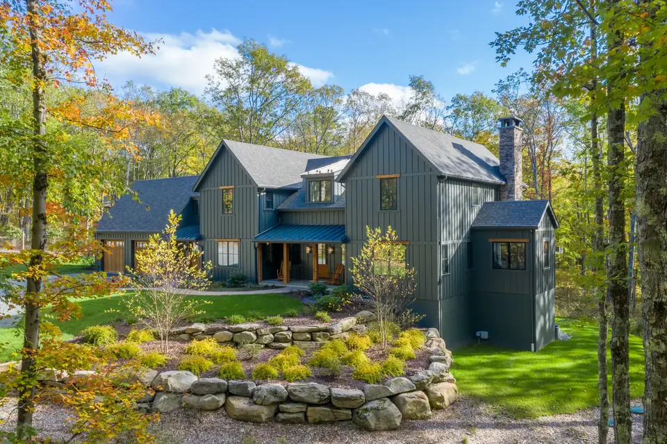 James Hardie siding inspiration: a green board and batten home among autumn trees
